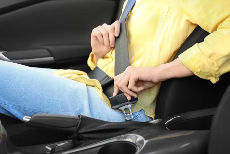 Occupant fastening a seat belt inside a car