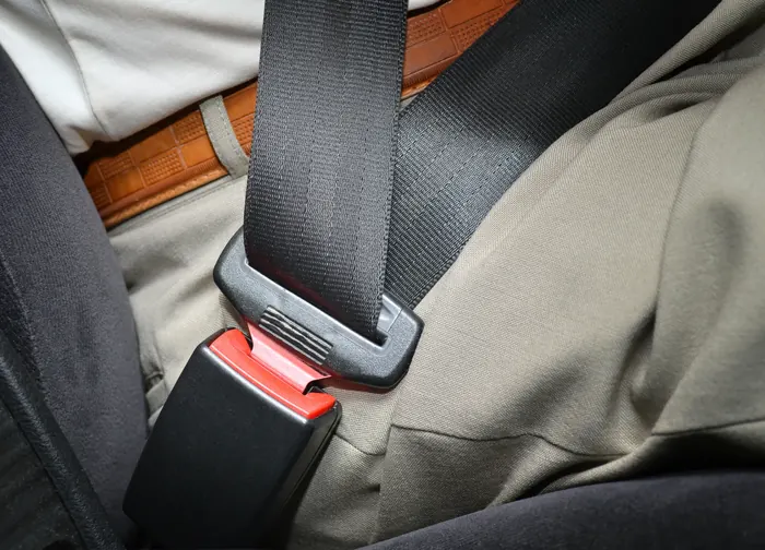 Fastened seat belt lying diagonally across an occupant seated in a vehicle