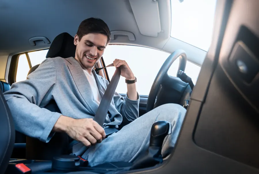 Occupant drawing the seat belt across the body in the front seat of a car